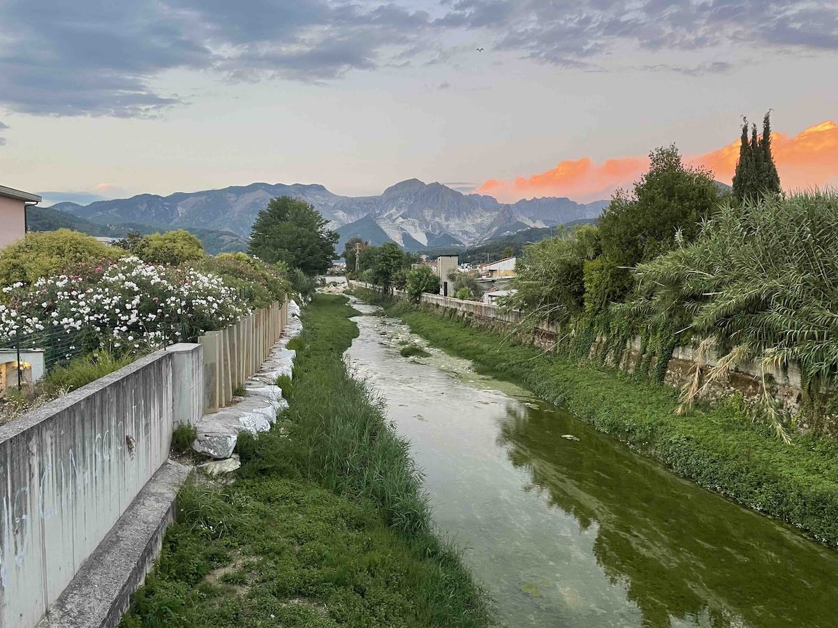 Via Francigena - Torrente Carrione al tramonto con vista sulle Alpi Apuane ad Avenza in Toscana